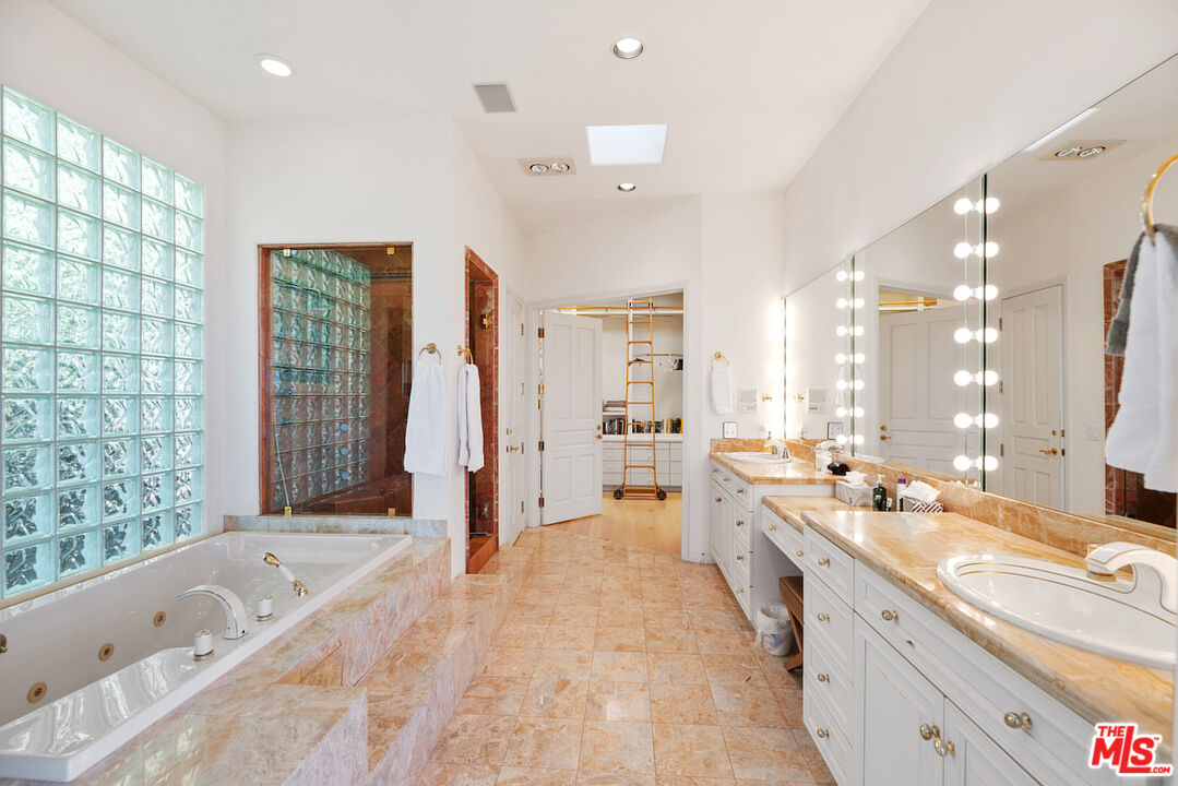 7350 Brodiaea Way La Jolla, CA 92037 - Photo 33 of 60 a large bathroom with a large tub sink and glass door