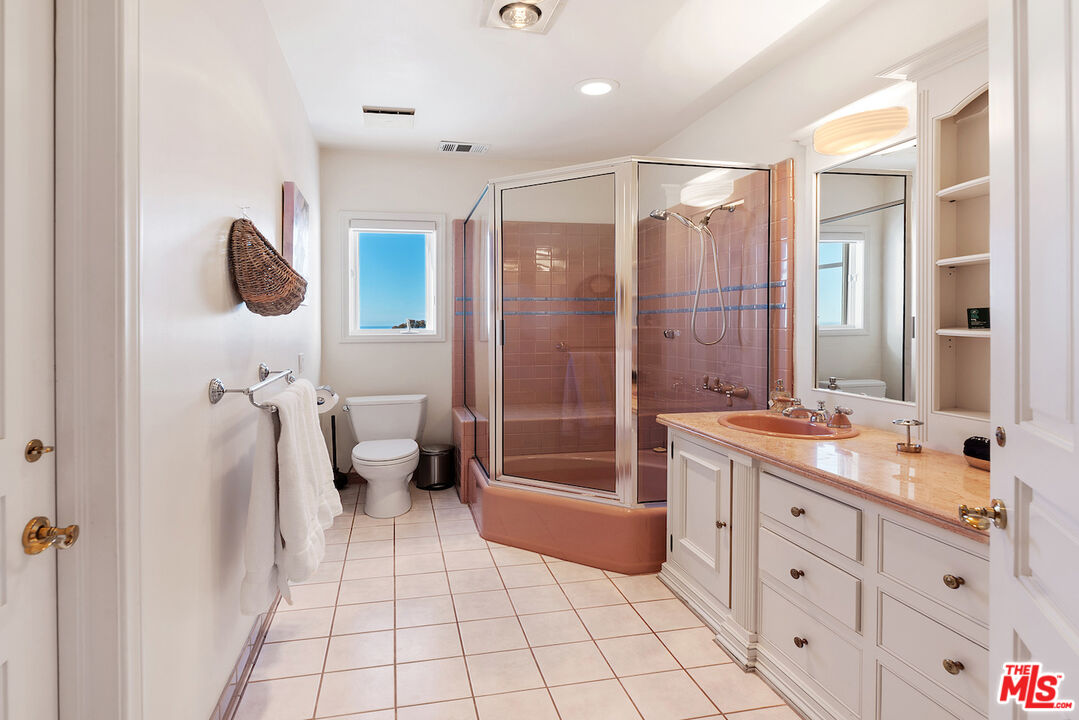 7350 Brodiaea Way La Jolla, CA 92037 - Photo 49 of 60 a bathroom with a double vanity sink a toilet a mirror and shower