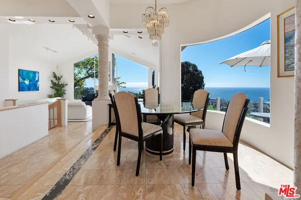 a kitchen with stainless steel appliances a dining table chairs stove and cabinets