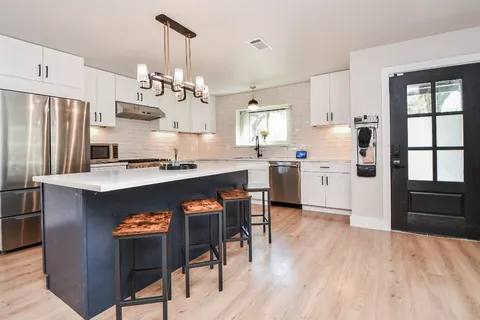 a kitchen with a counter space a sink and cabinets
