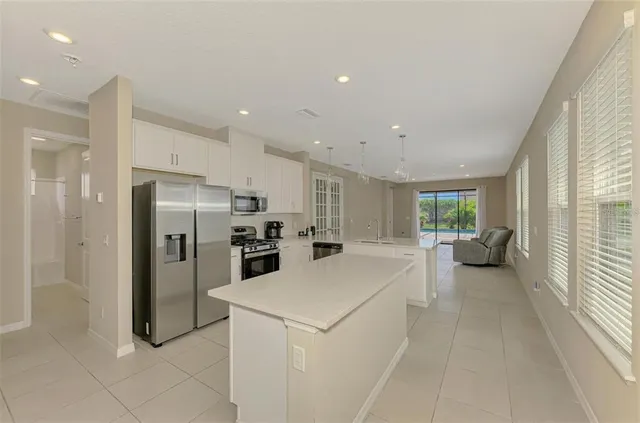 a large kitchen with a stove a refrigerator and a sink