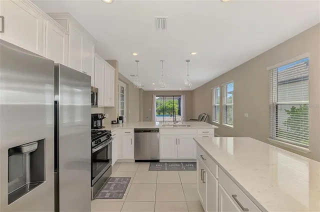 a kitchen with kitchen island a sink stainless steel appliances and cabinets