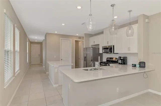 a kitchen with stainless steel appliances a refrigerator sink and microwave