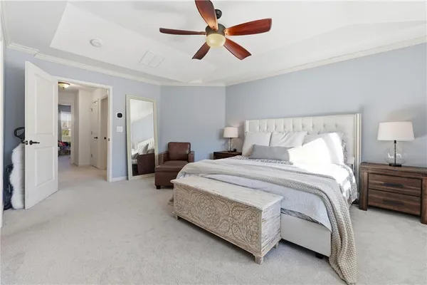 a spacious bedroom with a bed and ceiling fan