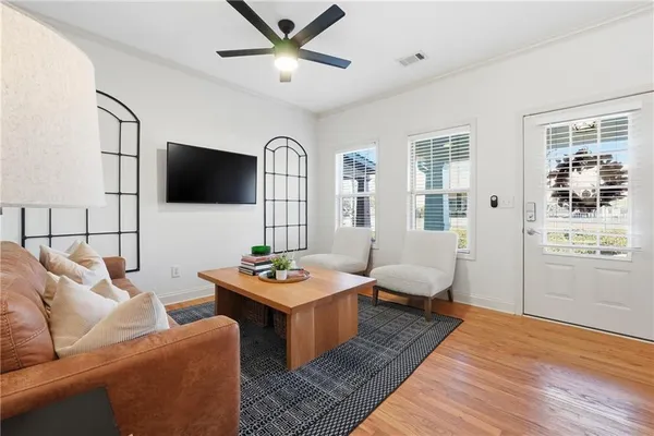 a living room with furniture a flat screen tv and a window