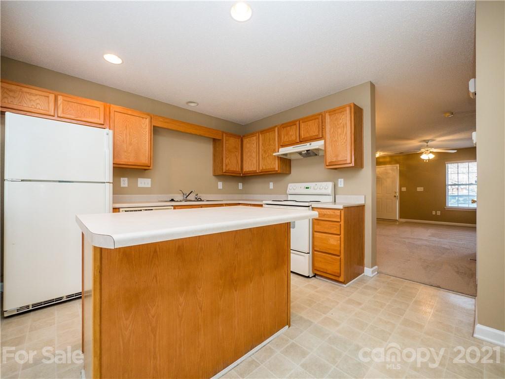 8178 Rudolph Road Charlotte, NC 28216 - Photo 11 of 20 a kitchen with stainless steel appliances a sink a stove a refrigerator a center island and cabinets