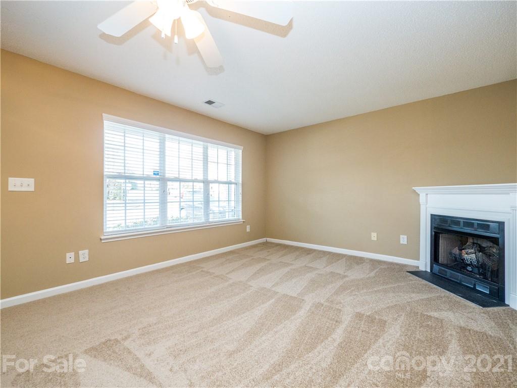 8178 Rudolph Road Charlotte, NC 28216 - Photo 7 of 20 a view of an empty room with a fireplace and a window