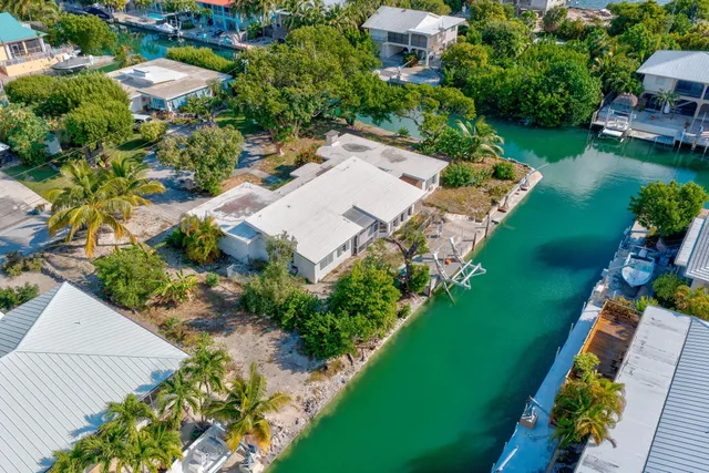 an aerial view of a house with a garden and lake view