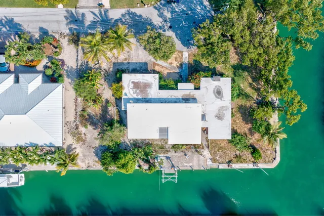 a view of a house with a yard and potted plants