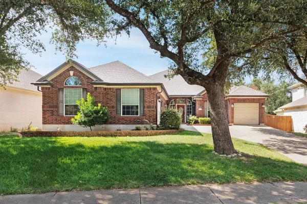 a front view of a house with a yard and trees