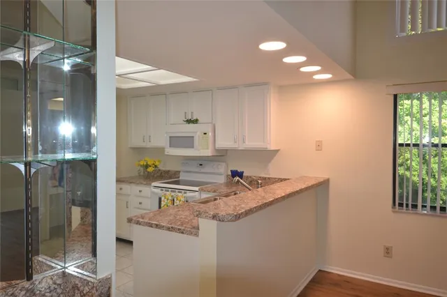 a kitchen that has a sink a refrigerator and window