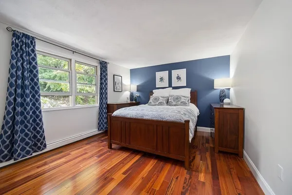 a bedroom with a bed and wooden floor