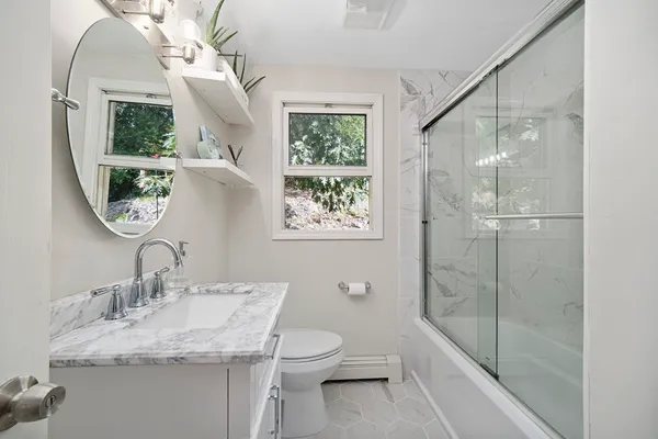 a bathroom with a granite countertop sink toilet and shower