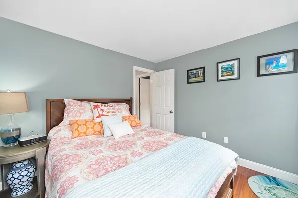 a bedroom with a bed and a lamp on dresser