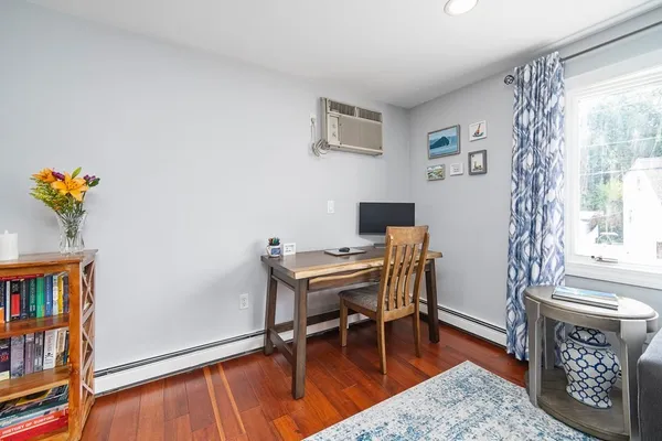 a view of a workspace with furniture and a window