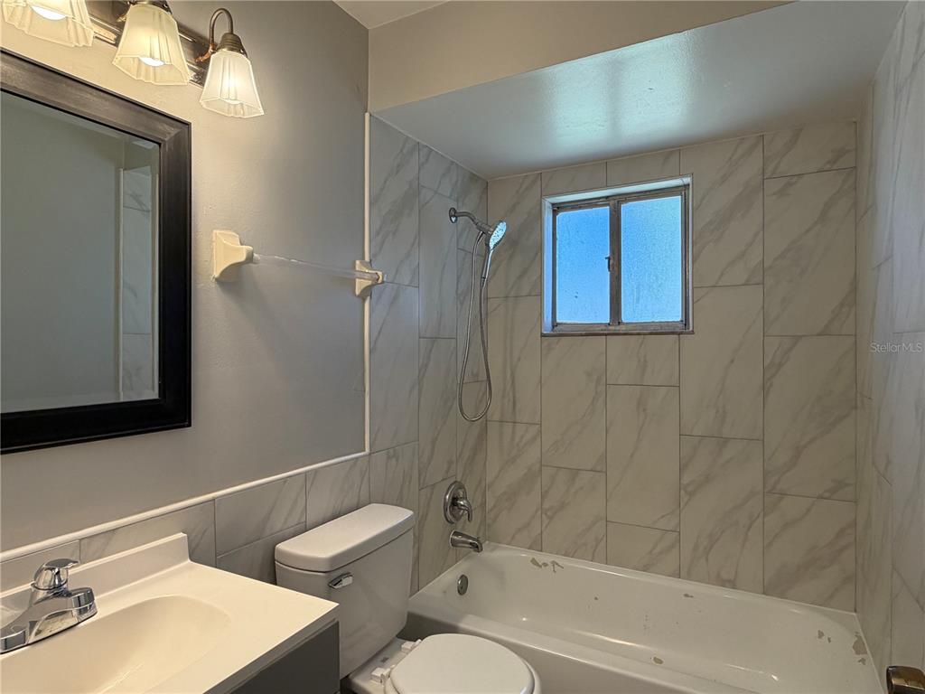 1215 Ravida Circle Orlando, FL 32825 - Photo 13 of 22 a bathroom with a bathtub shower sink vanity and toilet