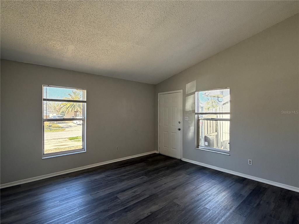 1215 Ravida Circle Orlando, FL 32825 - Photo 3 of 22 an empty room with wooden floor and windows
