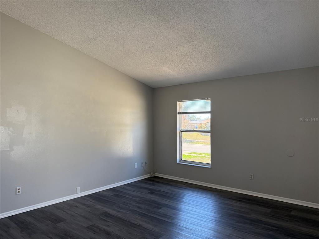 1215 Ravida Circle Orlando, FL 32825 - Photo 4 of 22 an empty room with wooden floor and windows