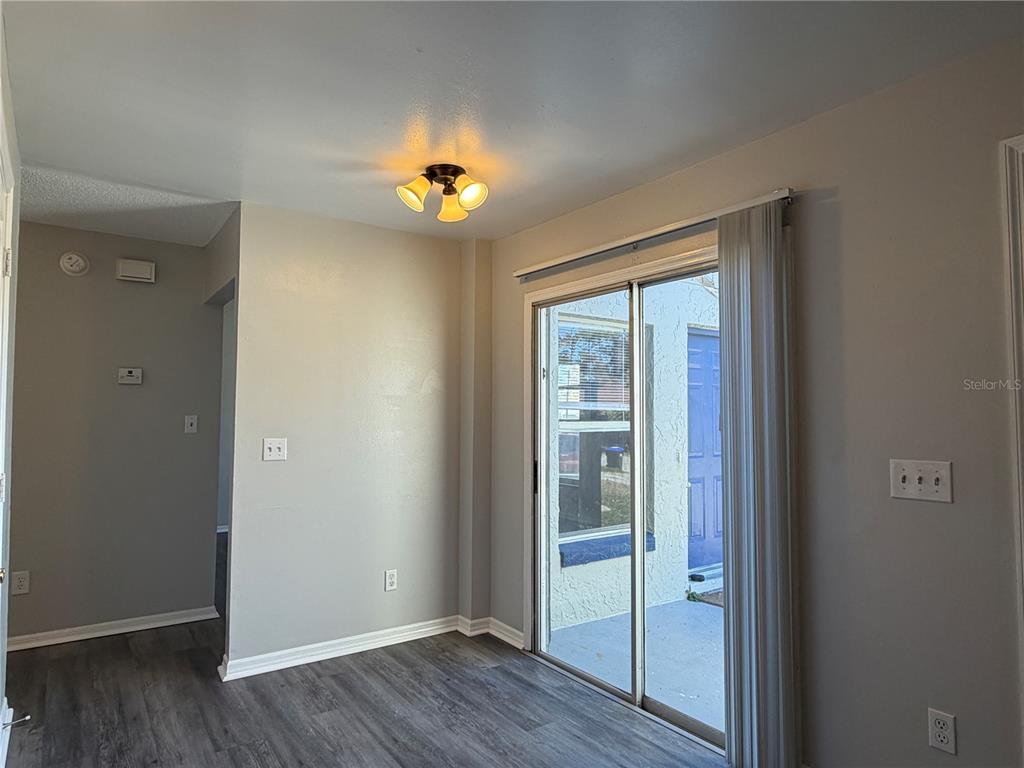 1215 Ravida Circle Orlando, FL 32825 - Photo 7 of 22 an empty room with wooden floor and sliding door