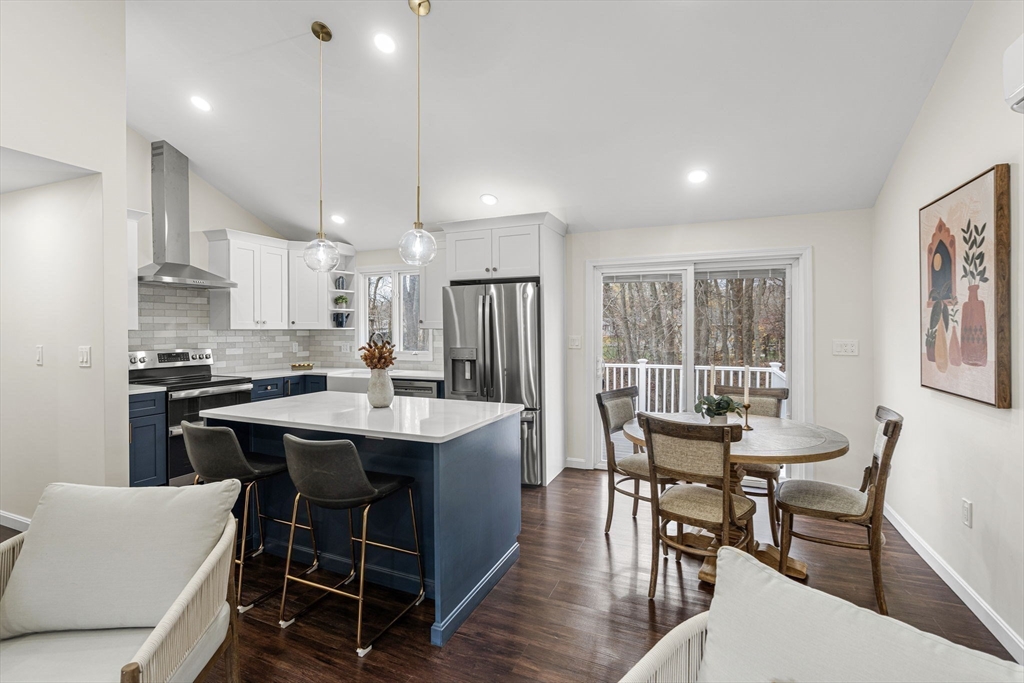 7 Old North Road Hudson, MA 01749 - Photo 7 of 39 a kitchen with kitchen island a dining table chairs and white cabinets