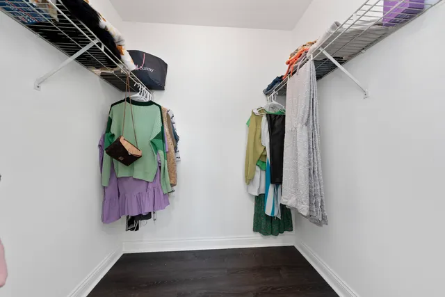 a view of walk in closet with clothes and shoes