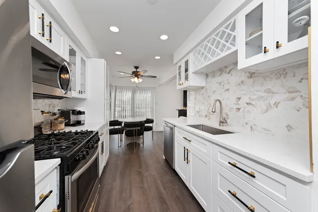 a kitchen with stainless steel appliances a sink stove and cabinets