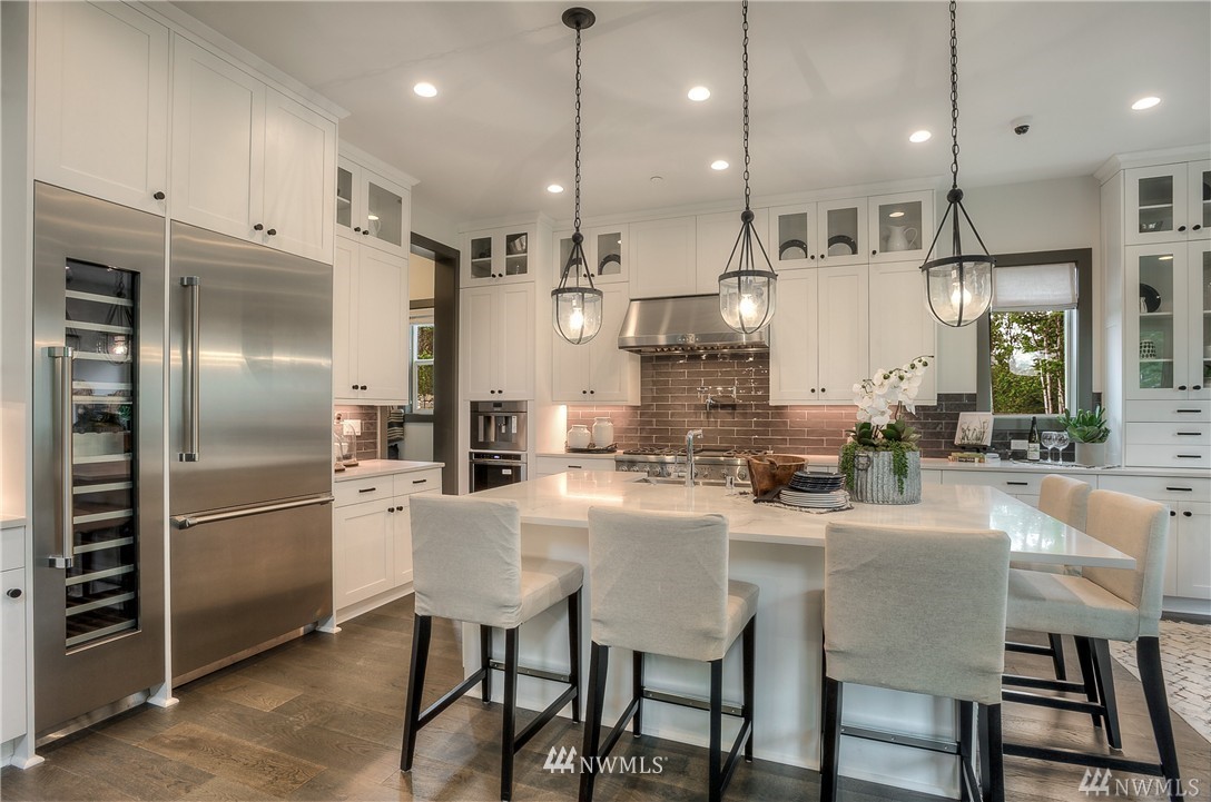 22009 33rd Drive Southeast, Unit 40 Bothell, WA 98021 - Photo 6 of 25 a kitchen with stainless steel appliances kitchen island granite countertop a table chairs refrigerator and microwave