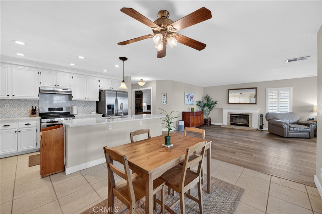 28322 Corte Ocaso Temecula, CA 92592 - Photo 30 of 75 a kitchen with stainless steel appliances kitchen island granite countertop a refrigerator a stove a sink a dining table and chairs with wooden floor