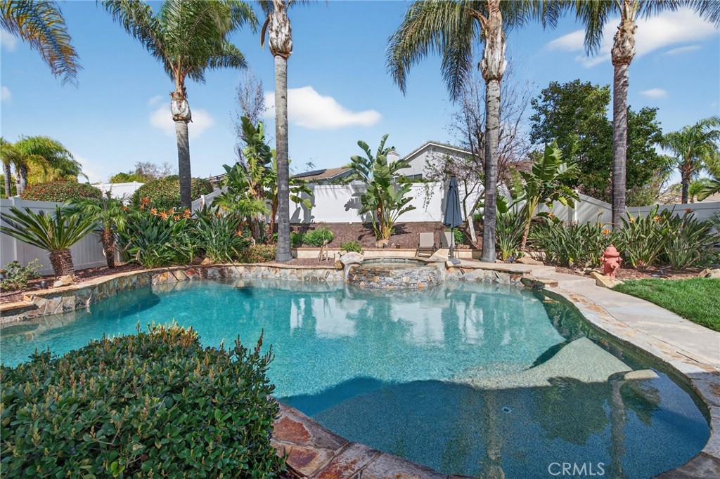 28322 Corte Ocaso Temecula, CA 92592 - Photo 60 of 75 a view of a swimming pool with a lawn chairs under palm trees
