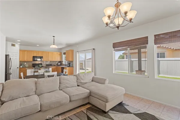 a living room with furniture a chandelier and a dining table