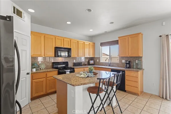 a kitchen with a refrigerator a stove a sink dishwasher and microwave with wooden floor