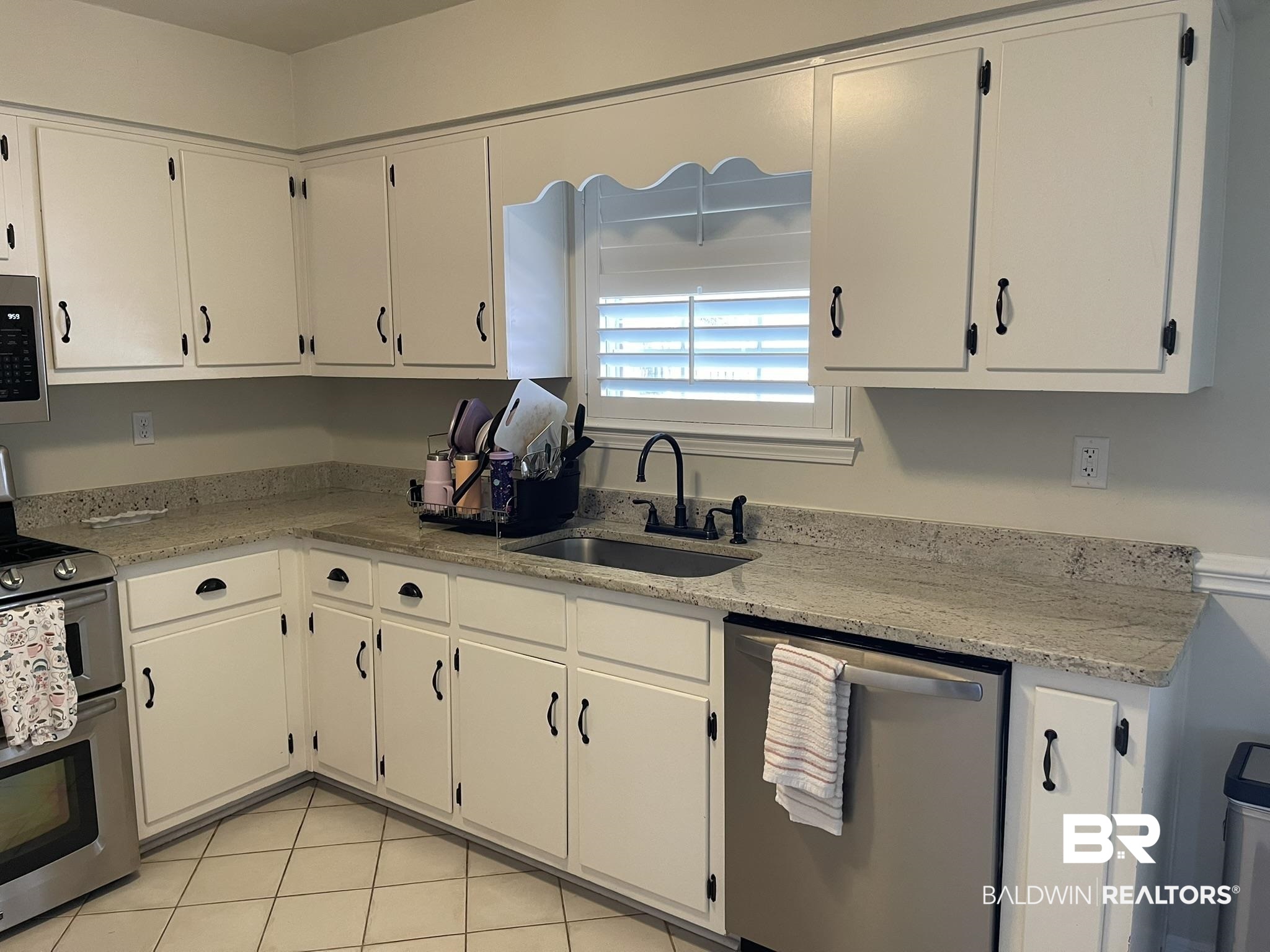 35405 Pine Road South Stapleton, AL 36578 - Photo 11 of 29 Kitchen featuring stainless steel appliances, light stone counters, light tile patterned floors, and white cabinets