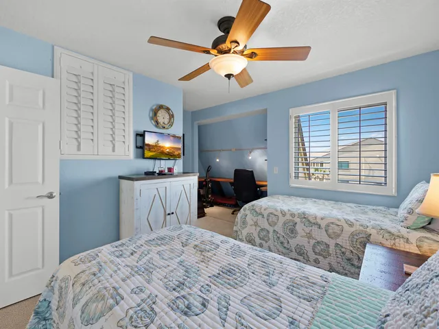 a bedroom with two large bed and a chandelier