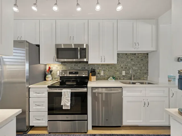 a kitchen with stainless steel appliances granite countertop a stove a sink and a microwave