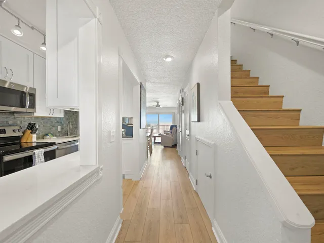 a view of a kitchen with wooden floor and electronic appliances