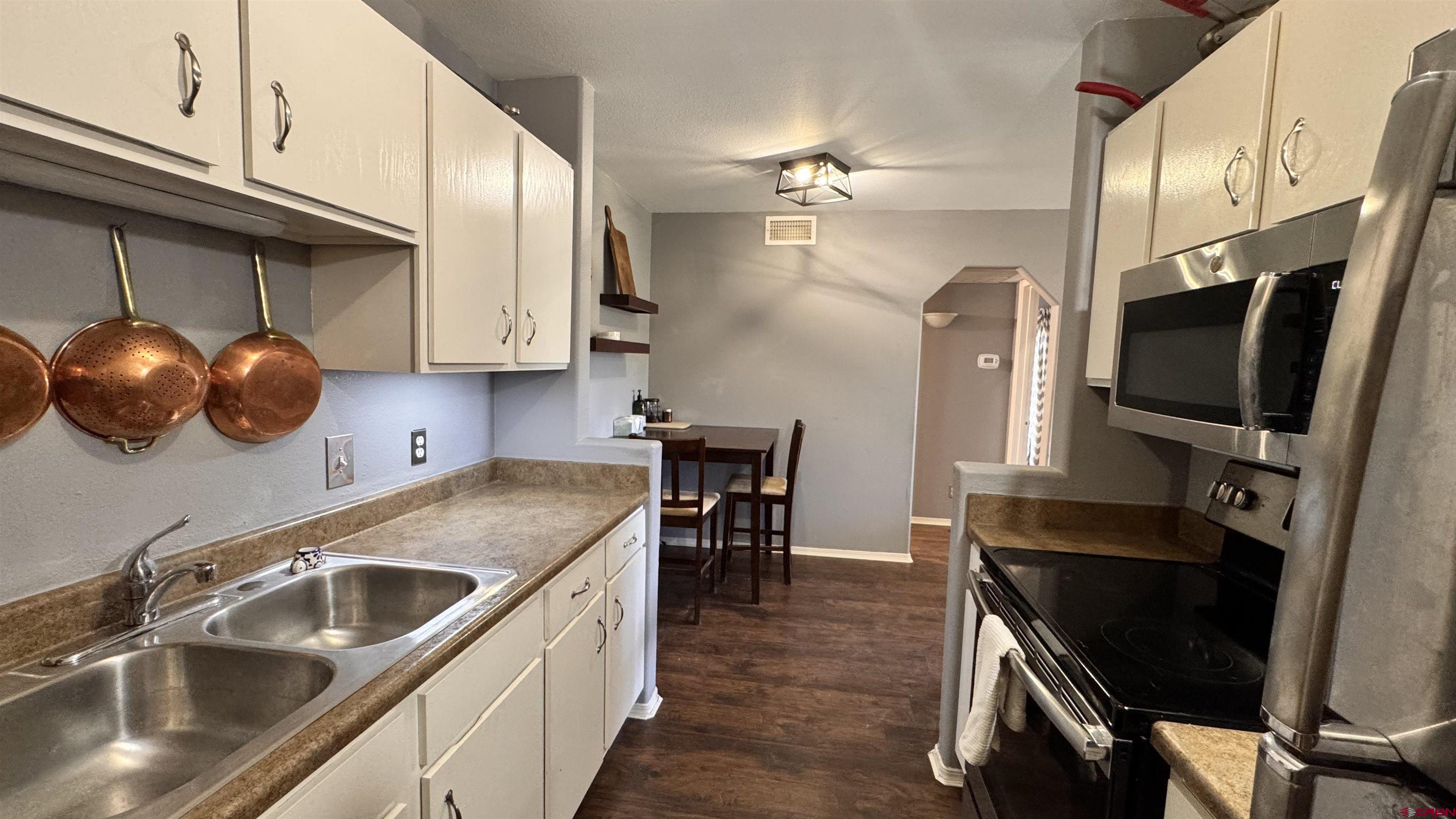 1100 Goeglein Gulch Road, Unit 204 Durango, CO 81301 - Photo 8 of 42 a kitchen with a sink a stove and chairs