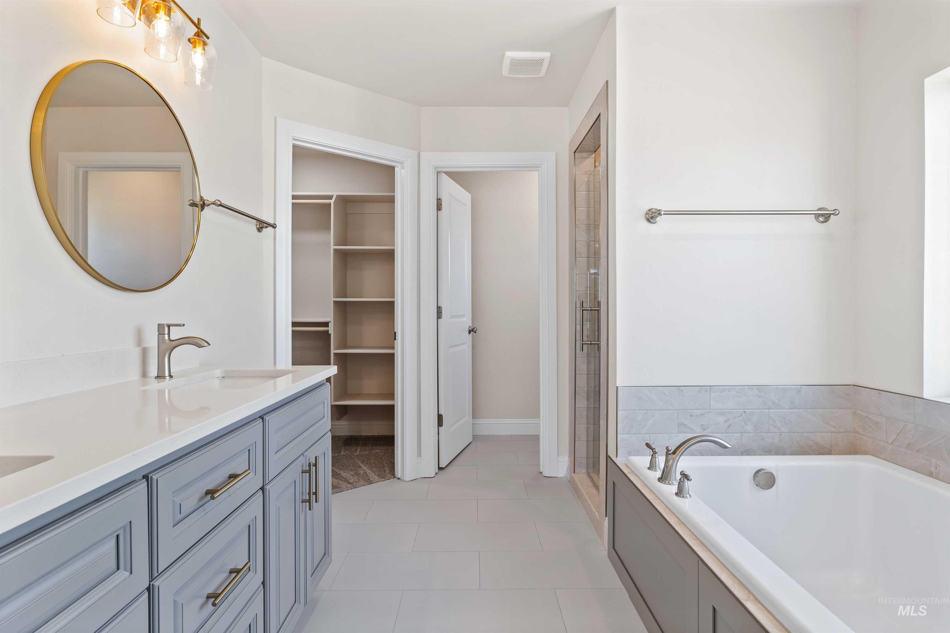 867 Adamite Road Kimberly, ID 83341 - Photo 11 of 24 Bathroom with a garden tub, double vanity, a shower stall, and tile patterned floors