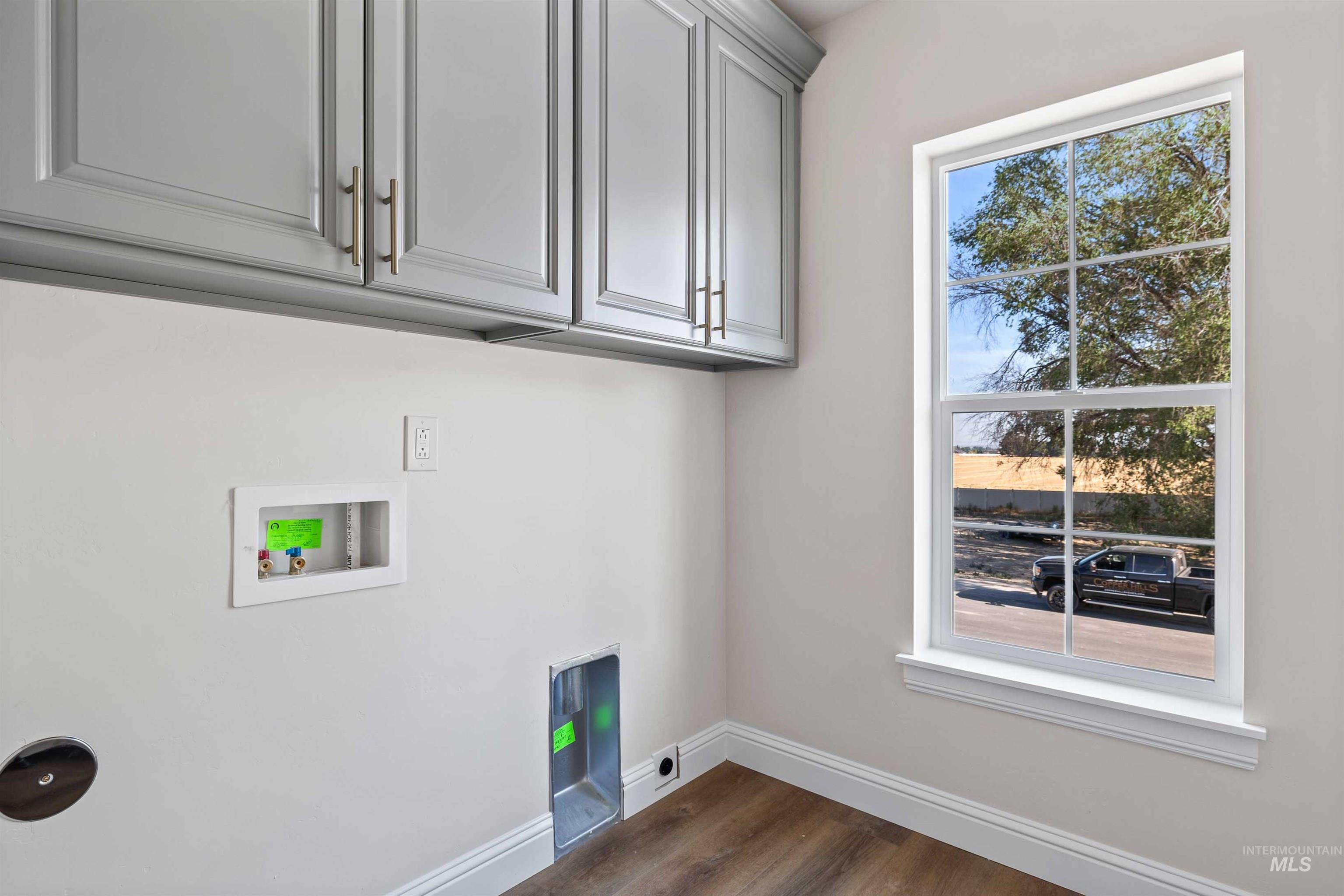 867 Adamite Road Kimberly, ID 83341 - Photo 18 of 24 Washroom with cabinet space, dark wood-type flooring, and washer hookup