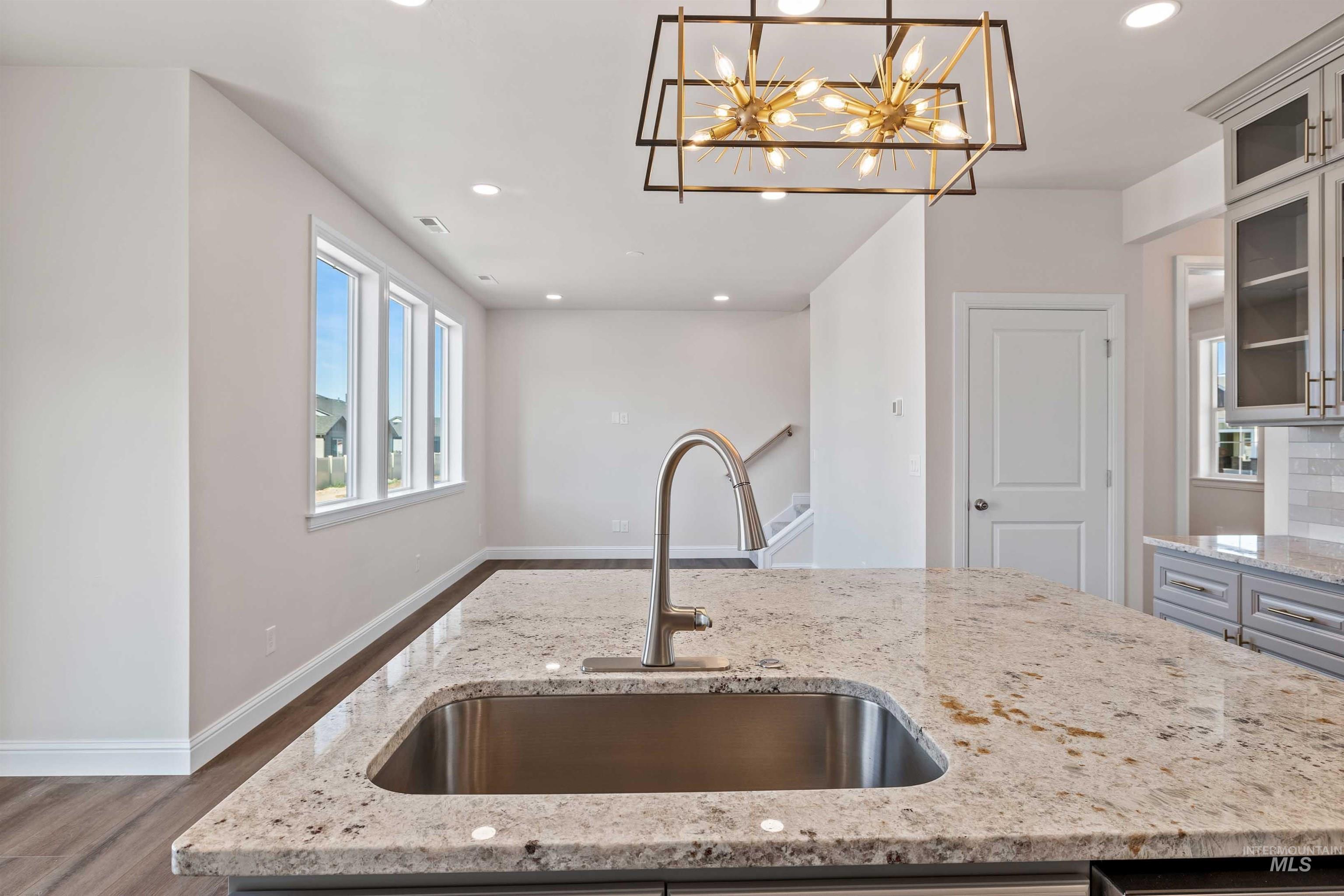 867 Adamite Road Kimberly, ID 83341 - Photo 8 of 24 Kitchen with wood finished floors, recessed lighting, light stone countertops, pendant lighting, and glass insert cabinets