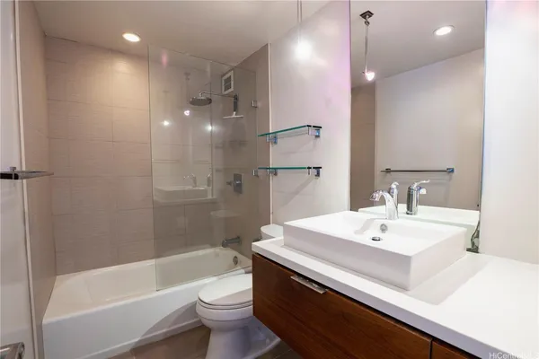 a bathroom with a sink a toilet a mirror and shower
