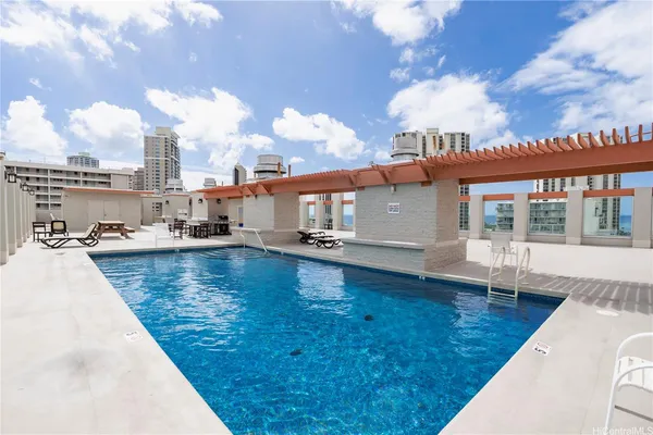 a view of a swimming pool with a lounge chairs in the patio