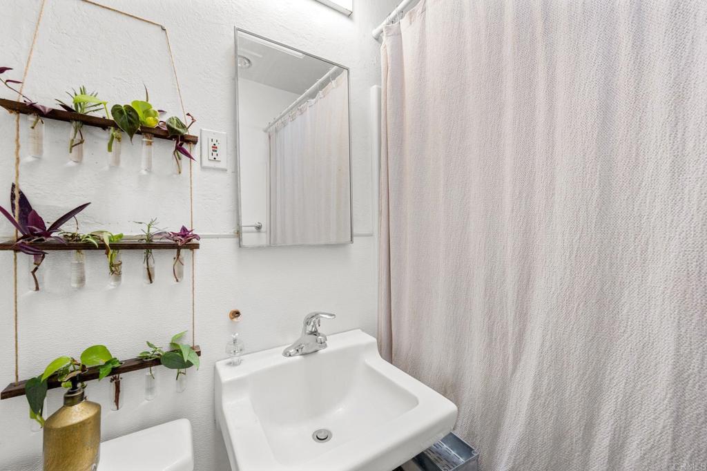 841 Normandy Road Encinitas, CA 92024 - Photo 14 of 38 a bathroom with a sink a mirror and a shower