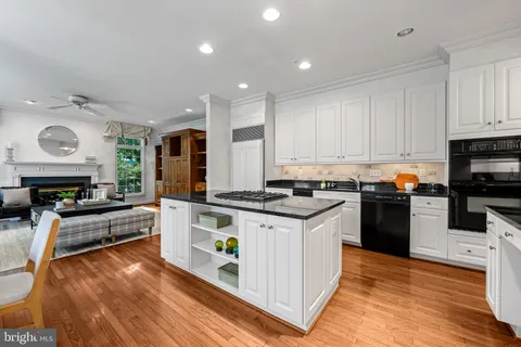 a kitchen with granite countertop a stove top oven and cabinets