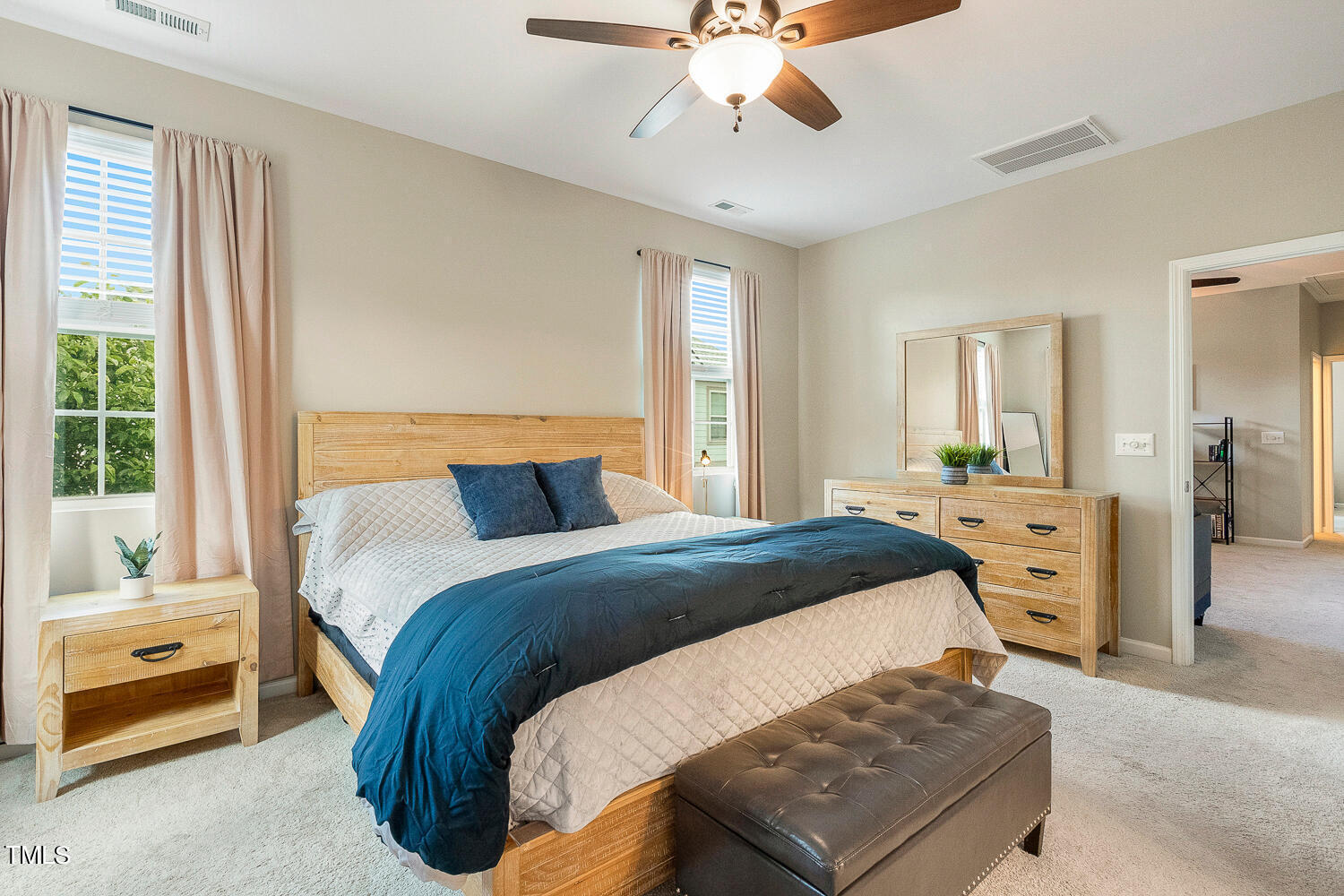 2425 Baslow Drive Apex, NC 27539 - Photo 27 of 48 a bedroom with a large bed and a chandelier