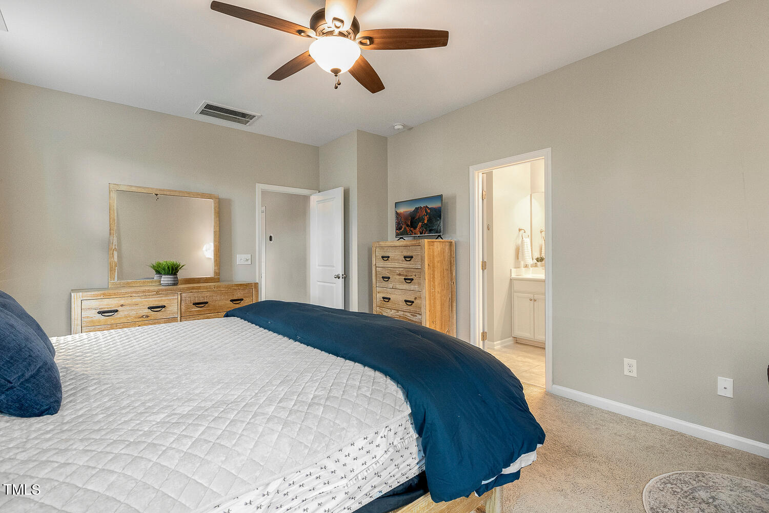 2425 Baslow Drive Apex, NC 27539 - Photo 28 of 48 a bedroom with a bed and a chandelier