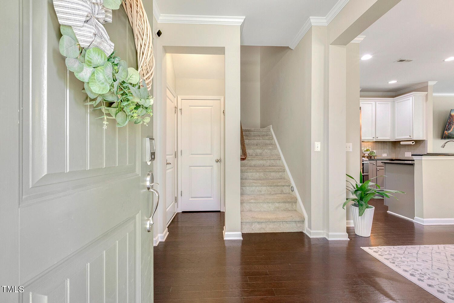 2425 Baslow Drive Apex, NC 27539 - Photo 5 of 48 a view of a hallway with wooden floor and a potted plant