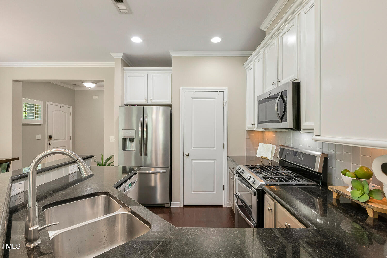 2425 Baslow Drive Apex, NC 27539 - Photo 7 of 48 a kitchen with granite countertop a sink stainless steel appliances and cabinets