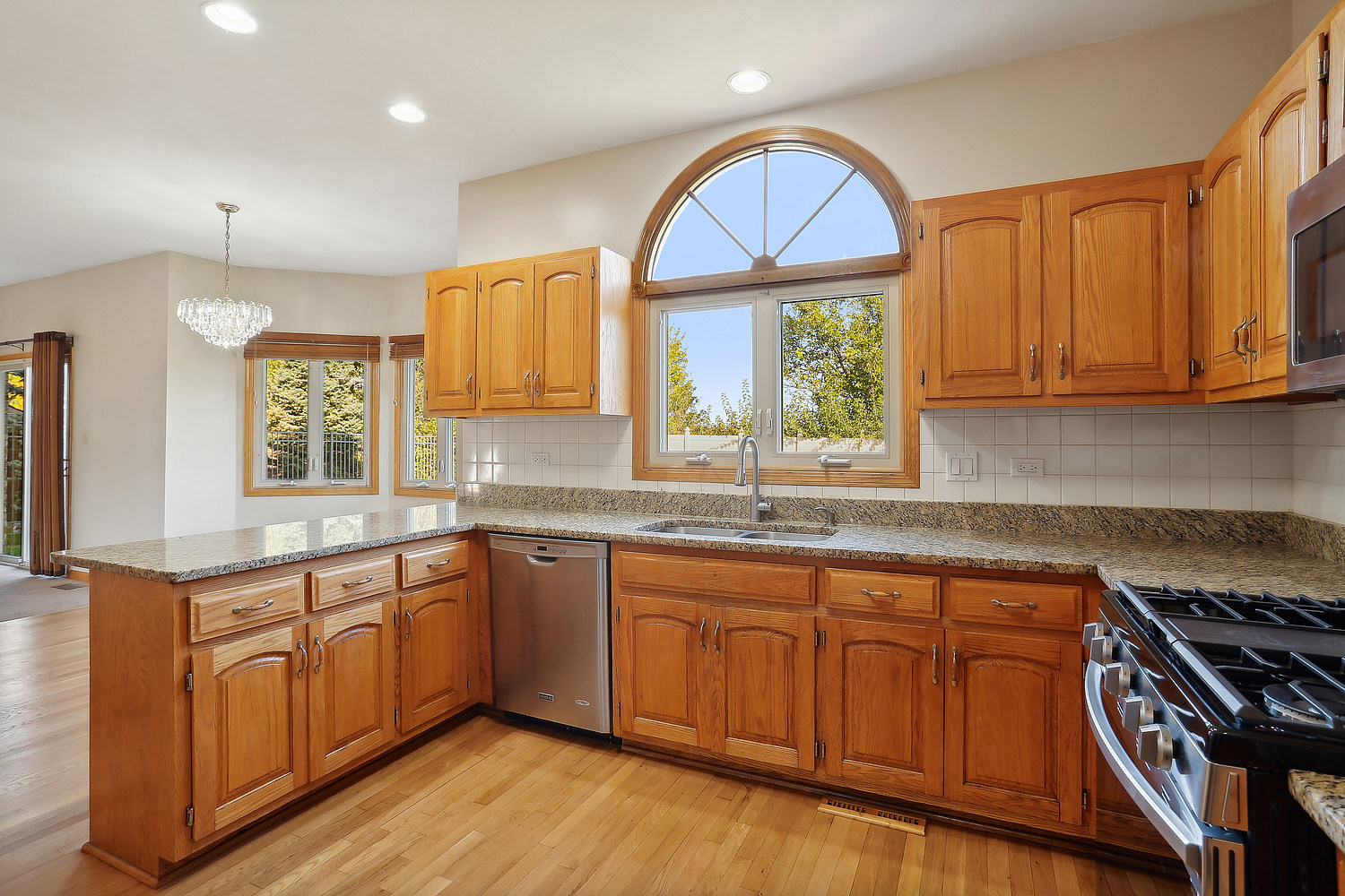 10646 Halligan Way Mokena, IL 60448 - Photo 17 of 28 a kitchen with wooden cabinets a sink a stove a window and wooden floor