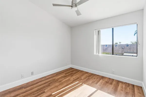 an empty room with wooden floor and window