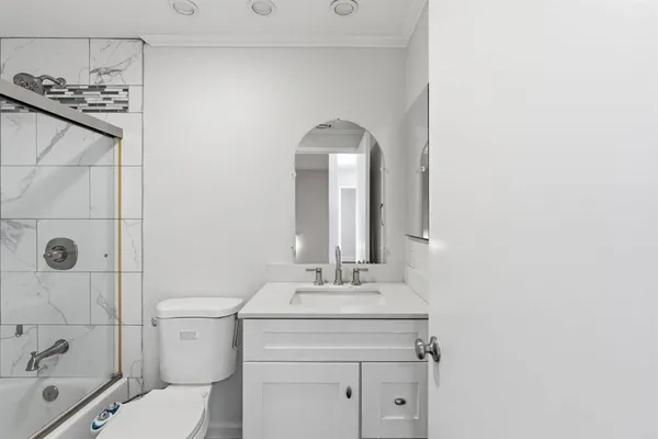 a bathroom with a granite countertop sink mirror vanity and toilet
